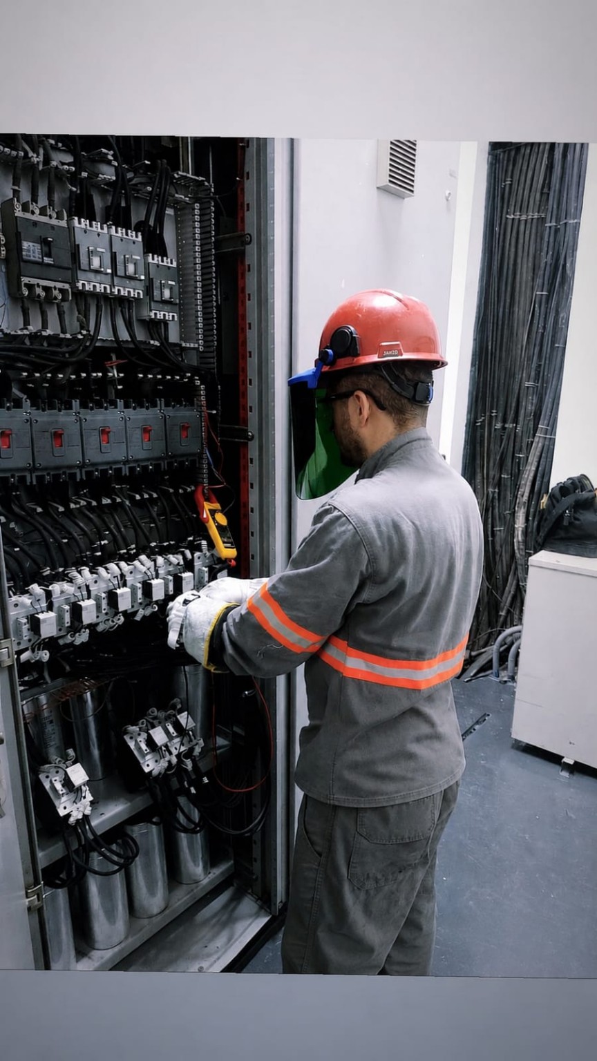Profissional realizando medição técnica em painel elétrico industrial