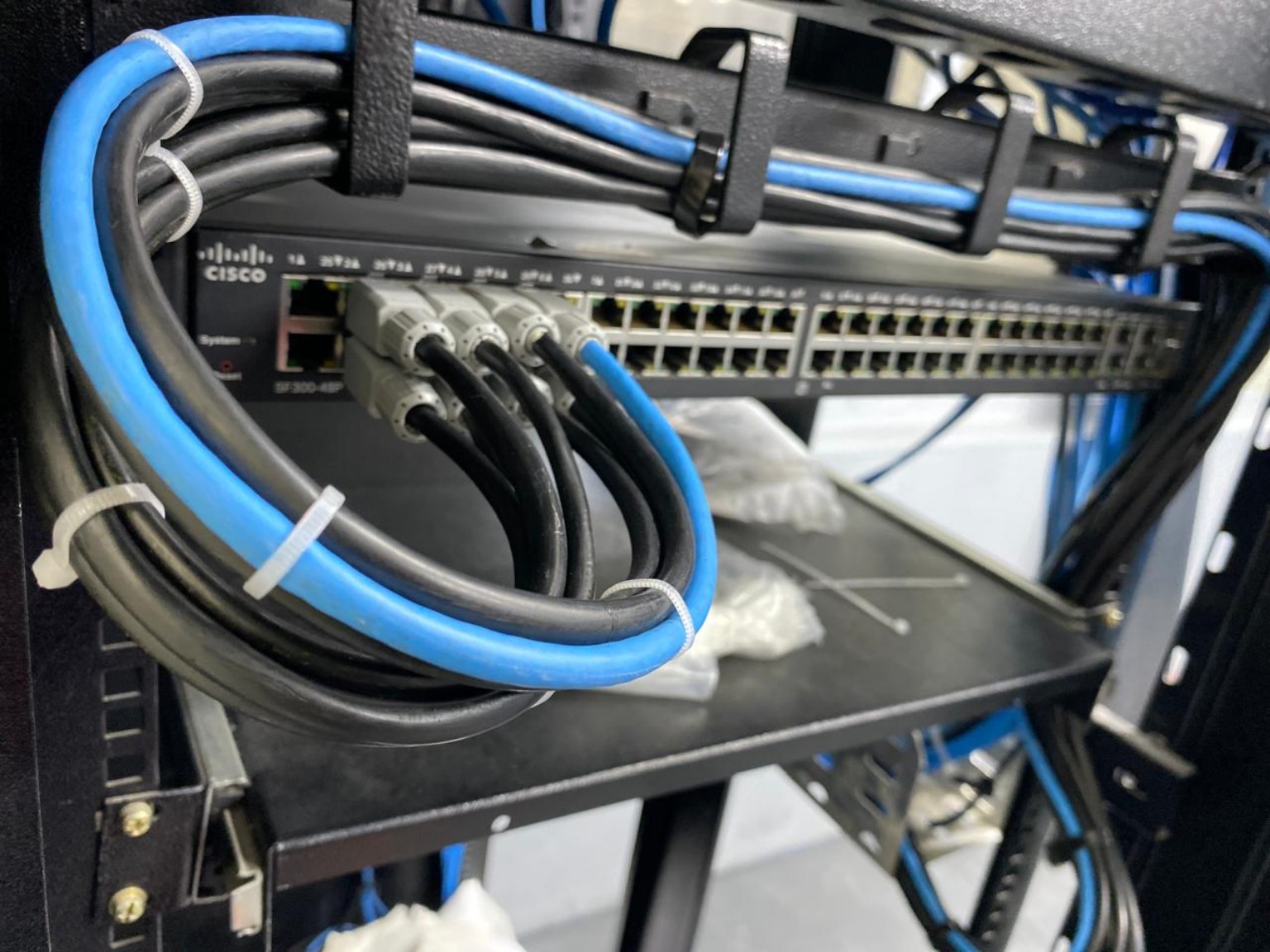Switch e cabeamento de rede instalados em rack industrial